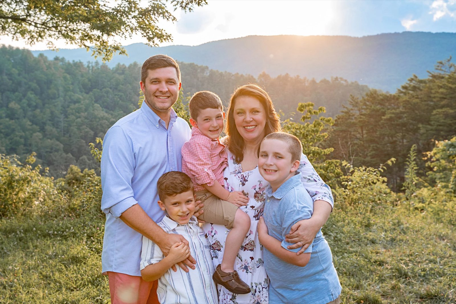 Chad and Bonnie Landman with their three sons on a mountainside at sunset
